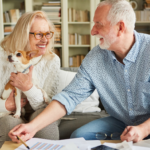 April 25 Events Page Image - The Atrium of Belleville Elderly man and woman smiling and holding small dog